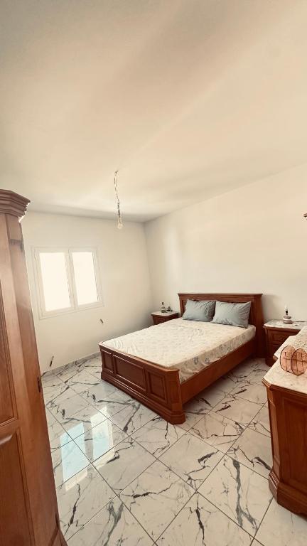 a bedroom with a large bed and a marble floor at Appartements de rêve in Hennchir Ksar Rhaleb