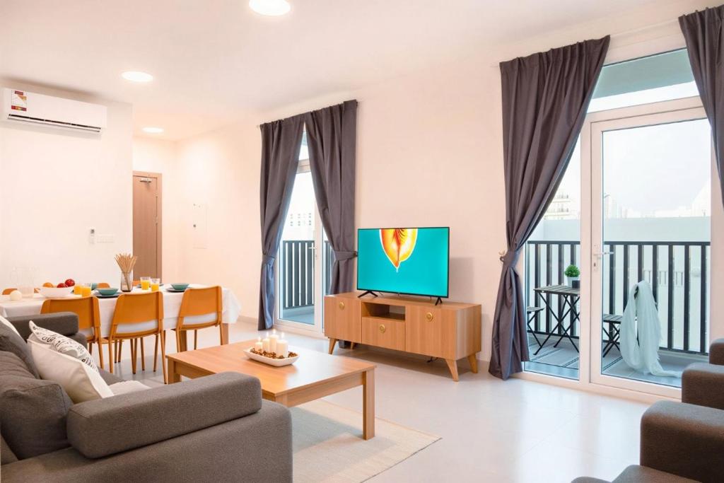 a living room with a couch and a tv and a table at The Pearl Nest Spacious 2BHK in Madinatna Better Than a Hotel, Halff the Price in Doha