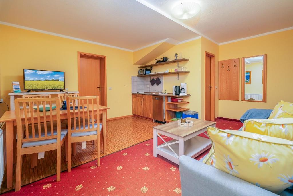 a living room with a table and a dining room at Leuchtfeuer in Thiessow