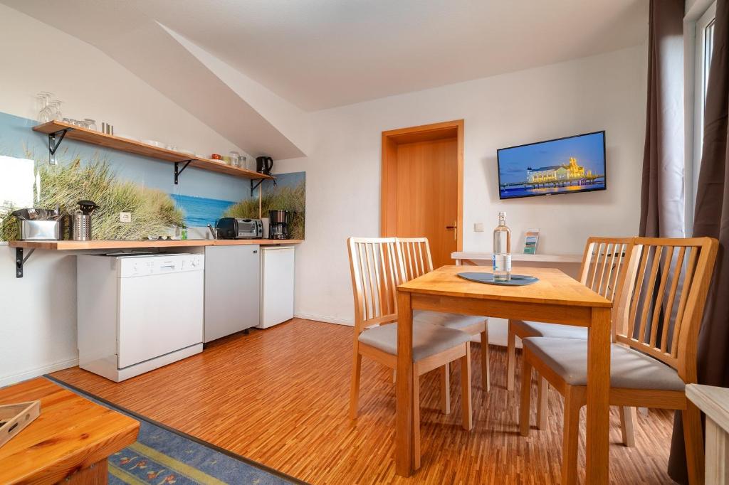 a kitchen and dining room with a wooden table and chairs at Heimathafen in Thiessow