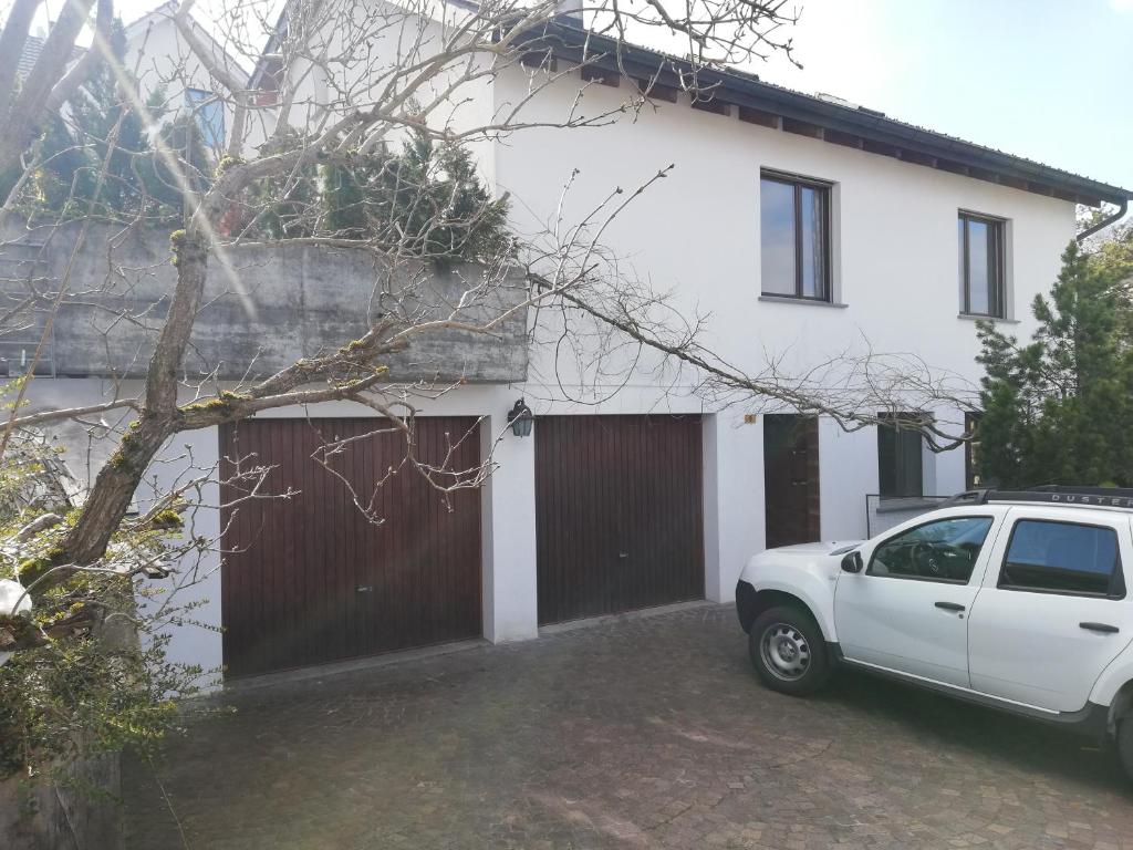 a white car parked in front of a house at Gästezimmer in einen Einfamilienhaus in Rudolfstetten