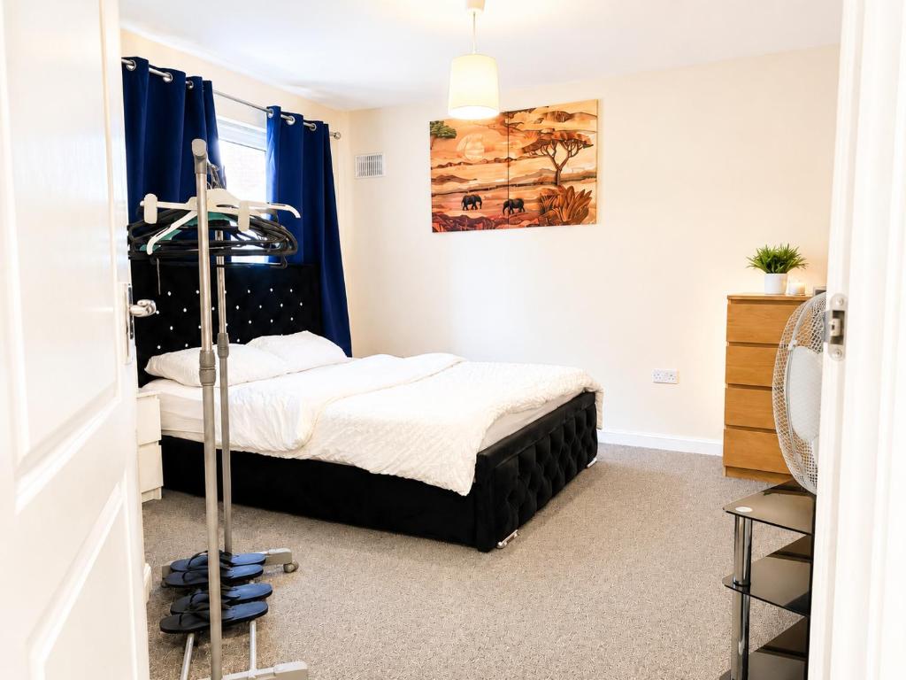 a small bedroom with a bed and blue curtains at Private Ensuite room in Wolverhampton city centre in Wolverhampton