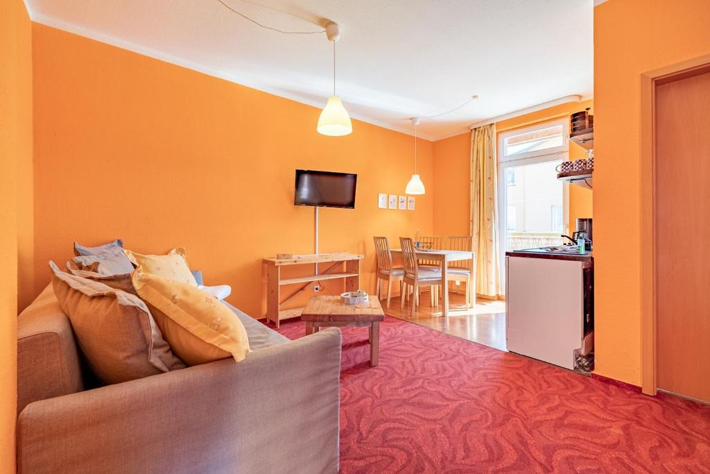a living room with orange walls and a couch at Wellengang in Thiessow