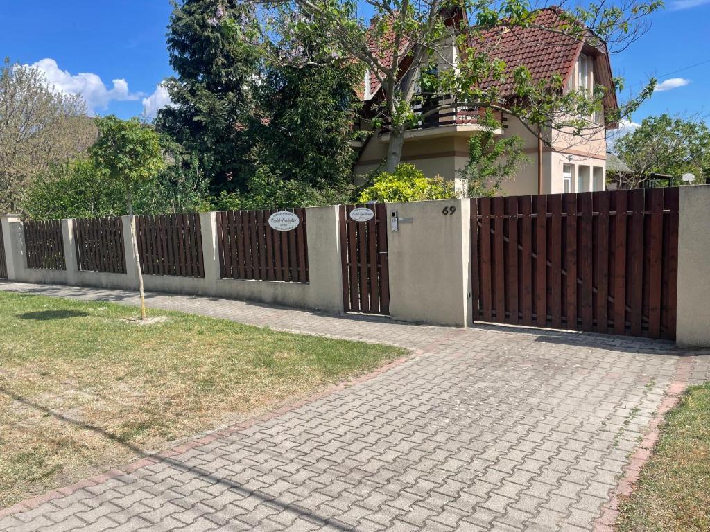 a wooden fence in front of a house at VÁRLAK VENDÉGHÁZ in Siófok
