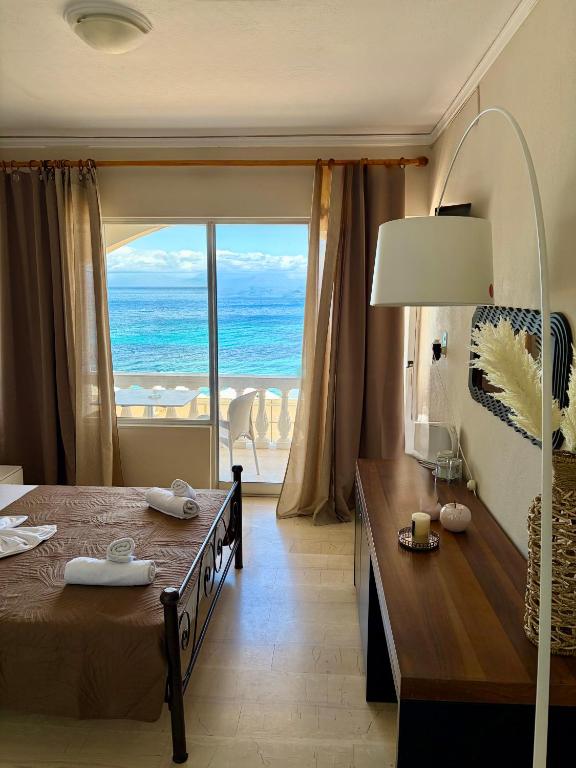 a bedroom with a bed and a view of the ocean at IONIAN MARE in Agios Ioannis Peristerion