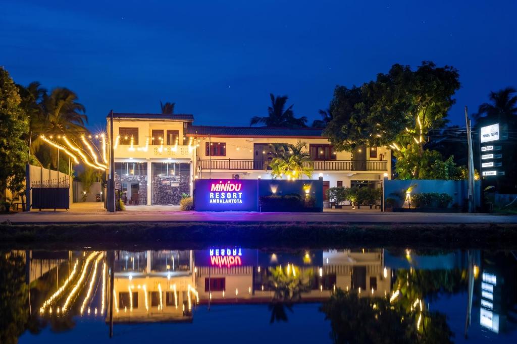 a hotel at night with its reflection in the water at minidu resort in Ambalantota