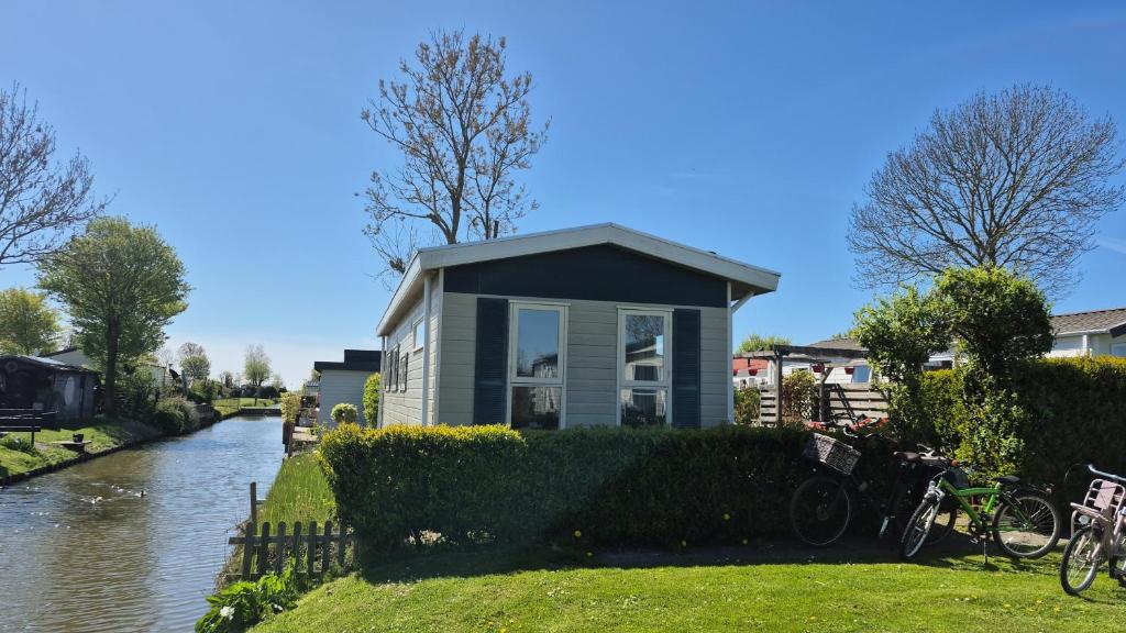 a small house on the side of a river at De vijverhut in Schagen
