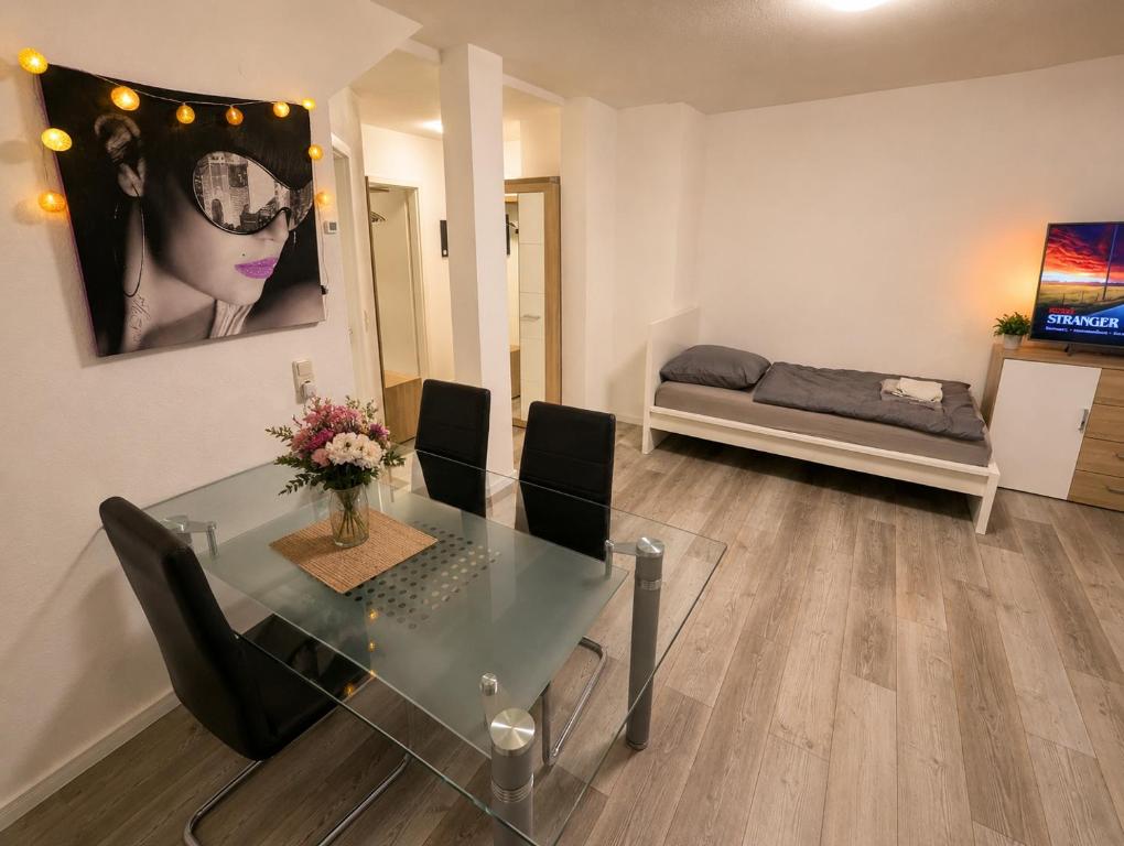 a dining room with a glass table and a bedroom at Mitarbeiterwohnung nahe Saaleck Kaserne in Hammelburg