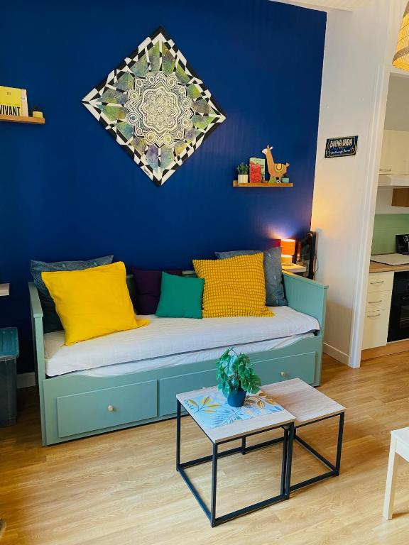 a blue living room with a couch and a table at Appartement hyper centre in Caen