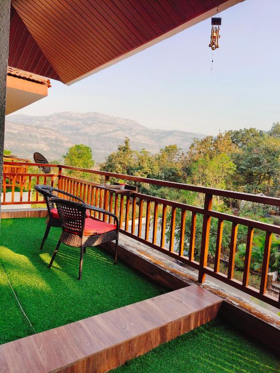 a chair sitting on a balcony with a view at Dreamview Mountains - Cozy 1bhk with Sunrise view in Karjat