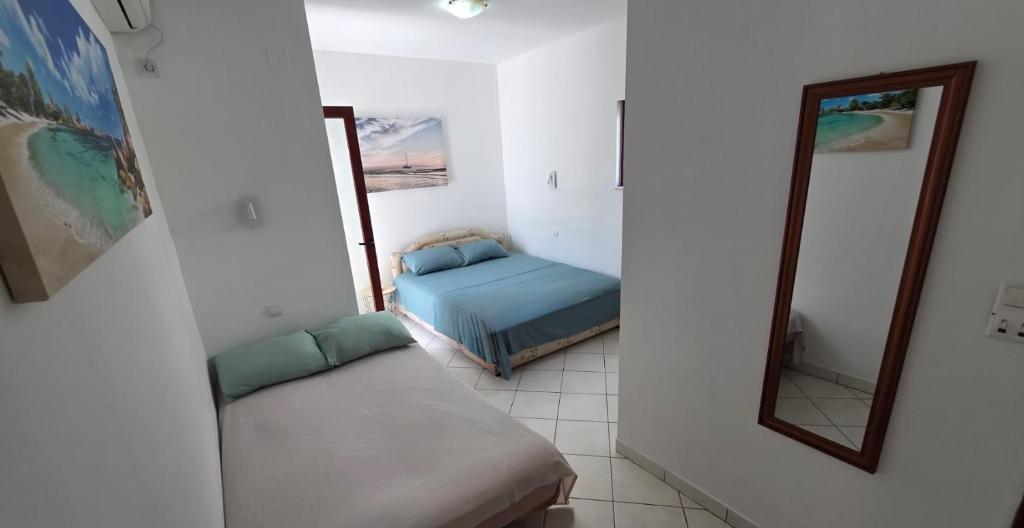 a small room with a bed and a mirror at Apartment Tara in Igalo