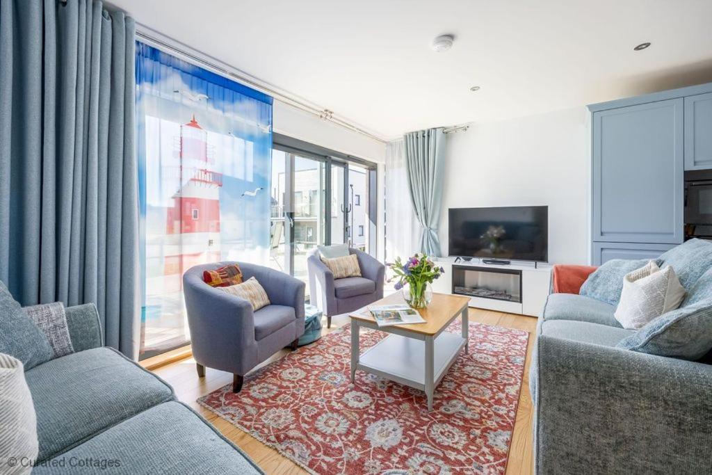 a living room with two couches and a tv at Dawn Lighthouse in Dorchester