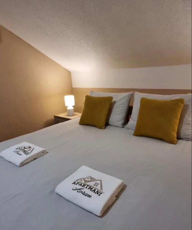 a large white bed with two towels on it at Apartman Avram in Kotor-Varoš