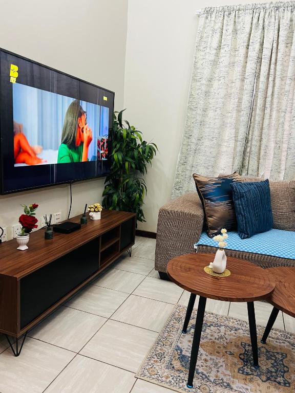 a living room with a couch and a flat screen tv at Brilliant Home in Gaborone