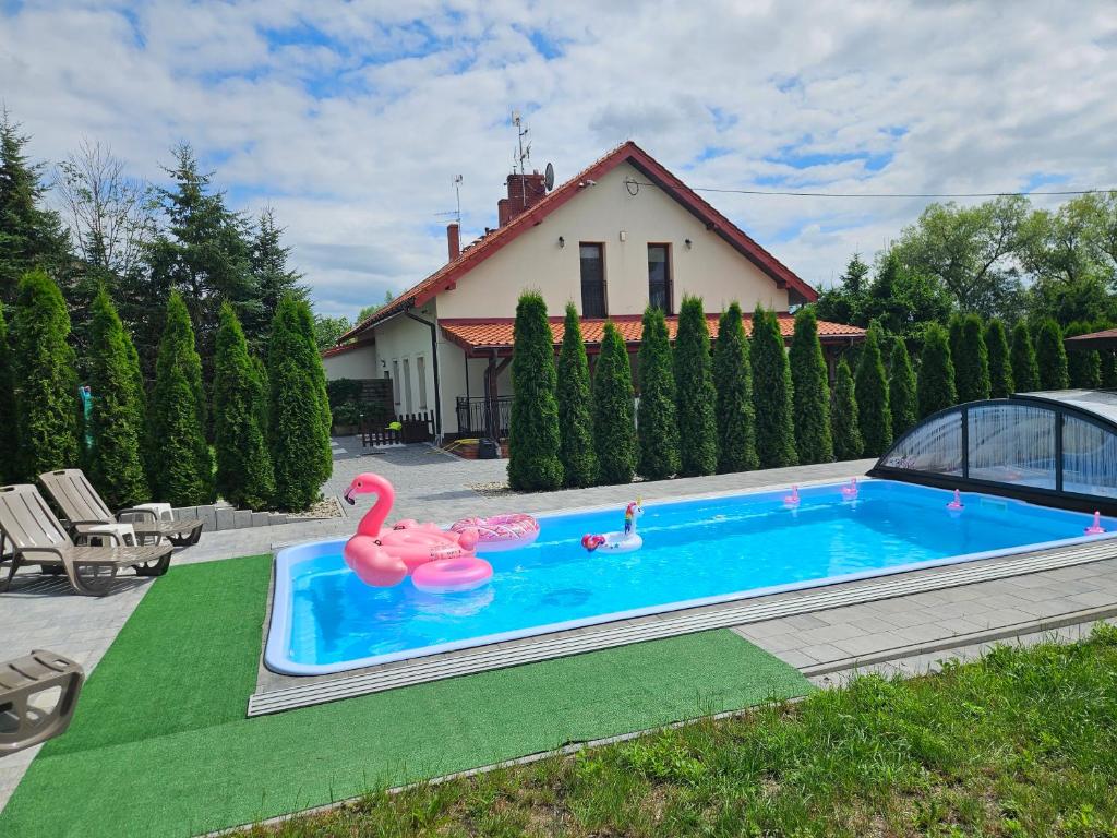 a swimming pool with two pink flamingos in a yard at Mazurska Tajemnica 1 in Łoje