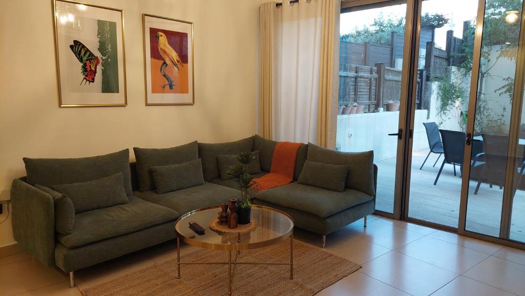 a living room with a couch and a table at Spacious Abdoun 2BR with private garden & pool access in Amman