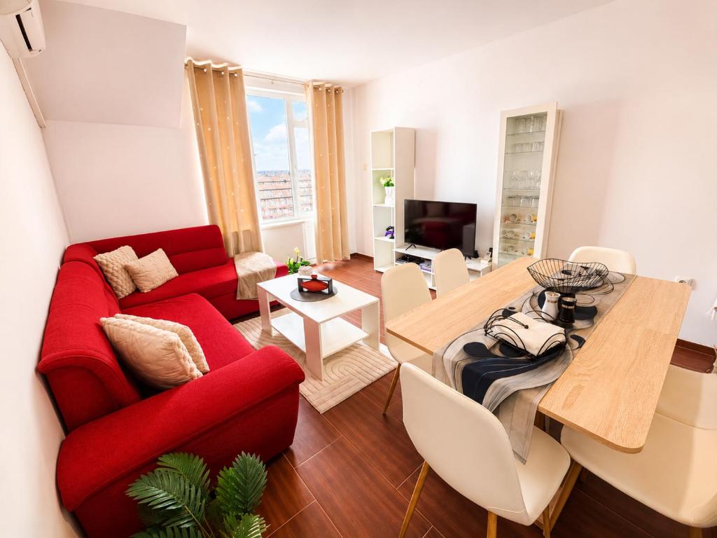 a living room with a red couch and a table at One-Bedroom flat Meden Rudnik zone B in Burgas