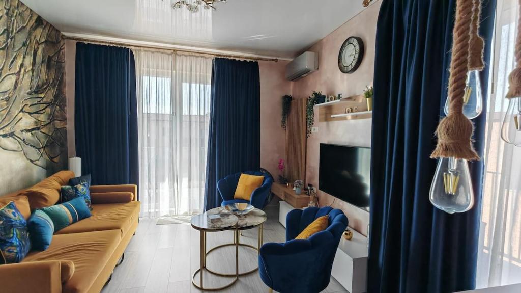 a living room with a couch and chairs and a tv at Onix Home Love 203 in Mamaia Sat/Năvodari