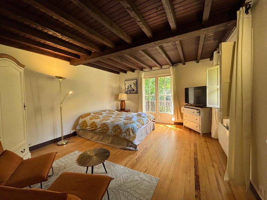 a bedroom with a bed and a television in it at La dépendance in Luchon
