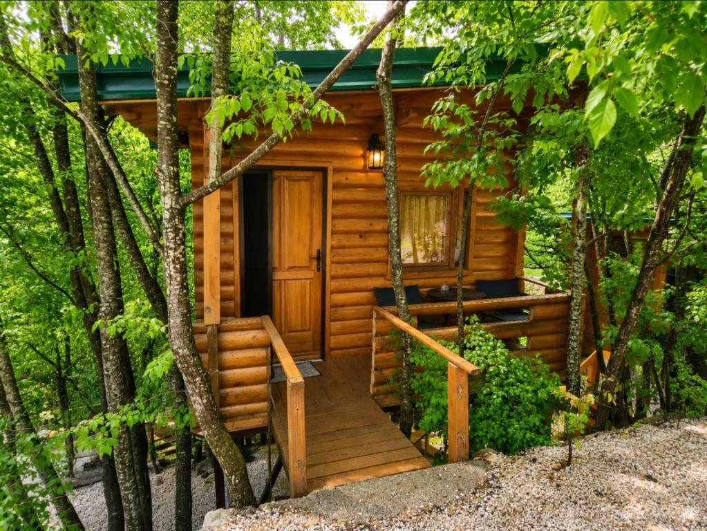 a log cabin in the woods with a wooden door at Still cabin in Cetinje