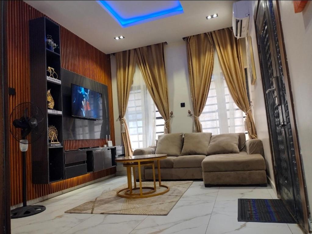 a living room with a couch and a table at OYO Serviced Apartment in Egbe