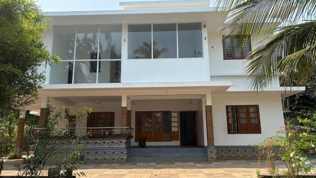 a house with large windows on the front of it at Mridanga Homestay in Iritti