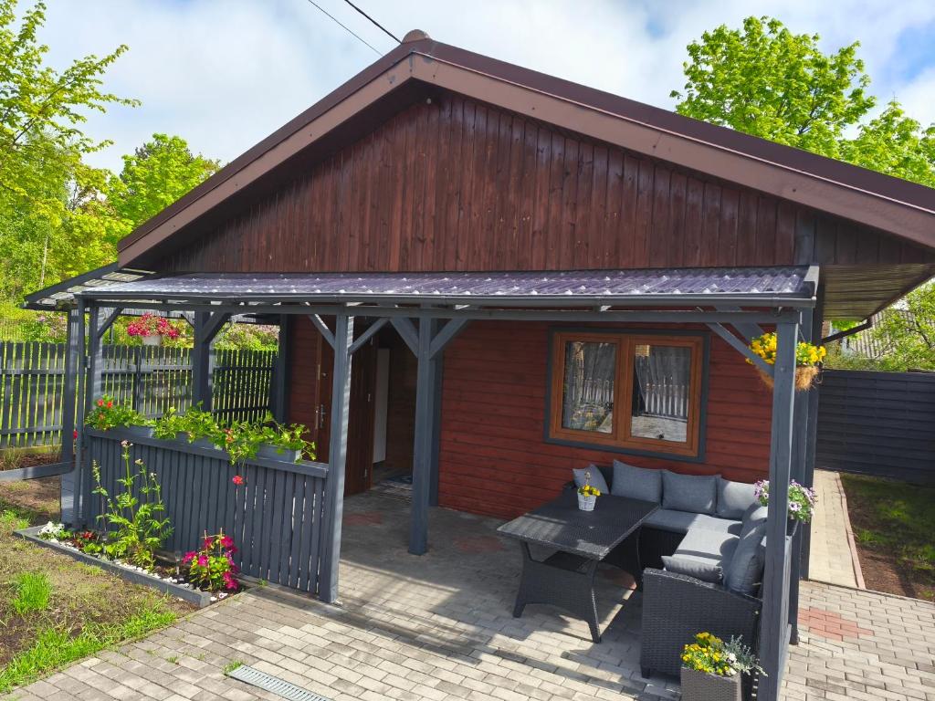 a shed with a couch and a table in front of it at Domek Słoneczny nad morzem in Kąty Rybackie