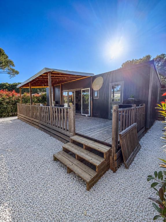 a house with a wooden deck with a bench at Mobil Home - 3CH - 2 SDB - Clim - Wifi in Roquebrune-sur-Argens