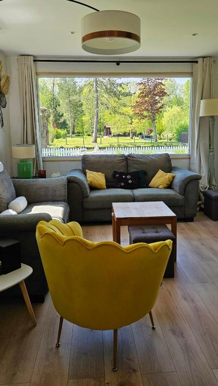 a living room with a couch and a yellow chair at Maison La Béa-titude in Serques