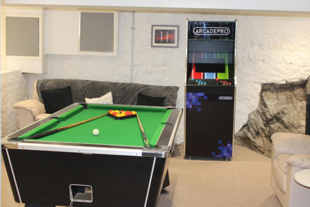 a game room with a pool table and a machine at Ty Clyd in Pembrokeshire