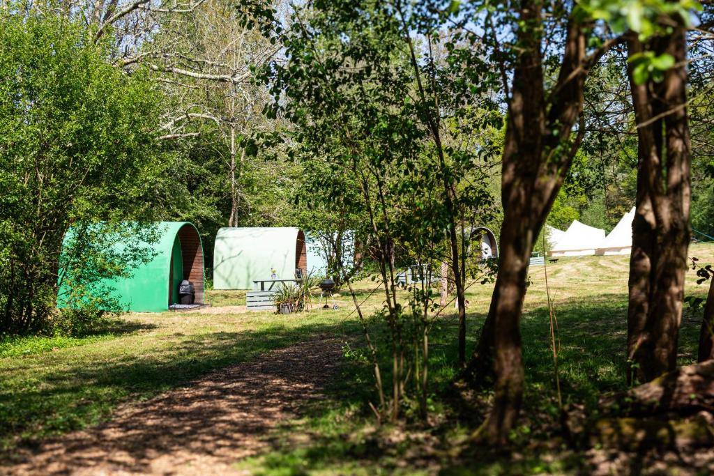 a group of tents in a field with trees at Battle Pods and Bells Glamping in Battle