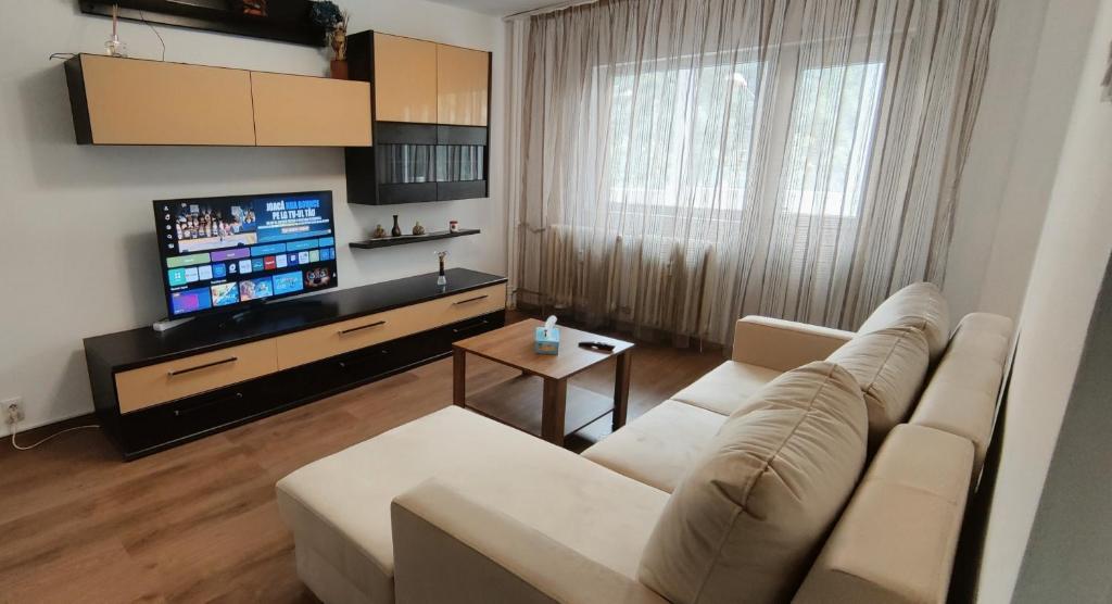 a living room with a couch and a flat screen tv at VLC Apartment in Bucharest