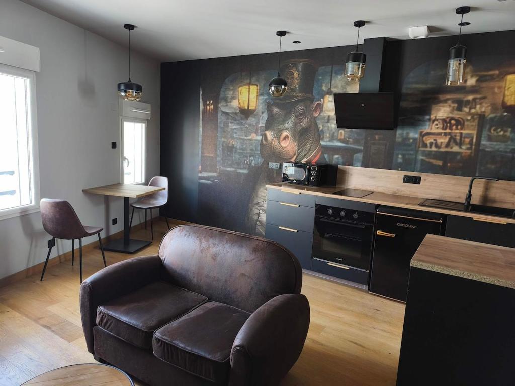 a living room with a leather chair and a kitchen at Escale à Clisson - l'Hippo Loft in Clisson