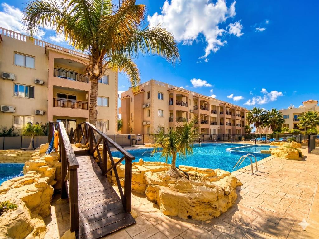 a resort with a swimming pool and palm trees at Sunshine Royal Seacrest- Prime Location Paphos with Pool in Paphos