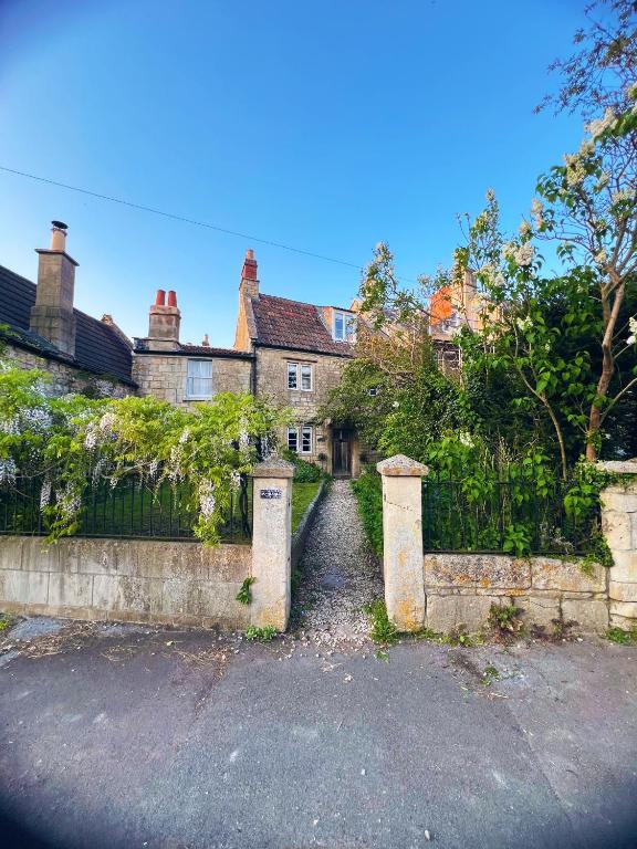 a house with a gate in front of it at Four bedroomed 18th century cosy cottage three miles from Bath City Centre in Batheaston