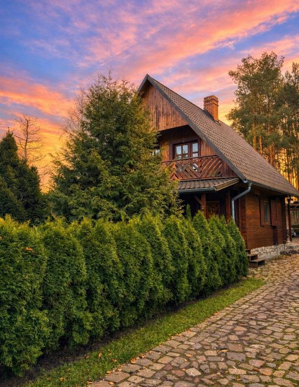 a house with a hedge in front of a building at Sowa i Kumple in Drezdenko