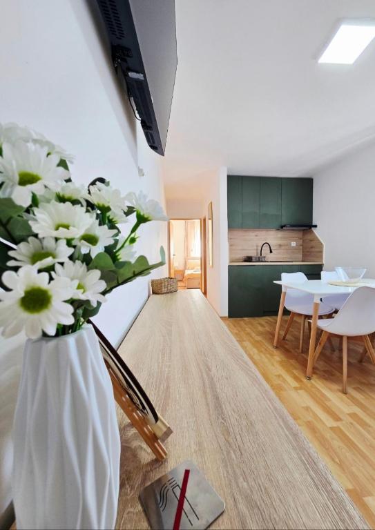 a vase with white flowers in a living room at Apartmani Marija - Vila Marija in Šilo