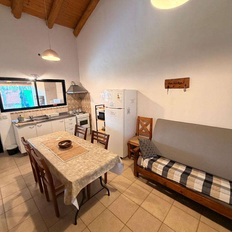 a kitchen and dining room with a table and a refrigerator at La Casita El Martillo in Concordia