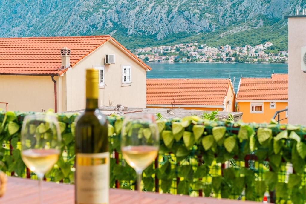 a bottle of wine sitting on a table with wine glasses at Prcanj Seaside Heaven in Prčanj