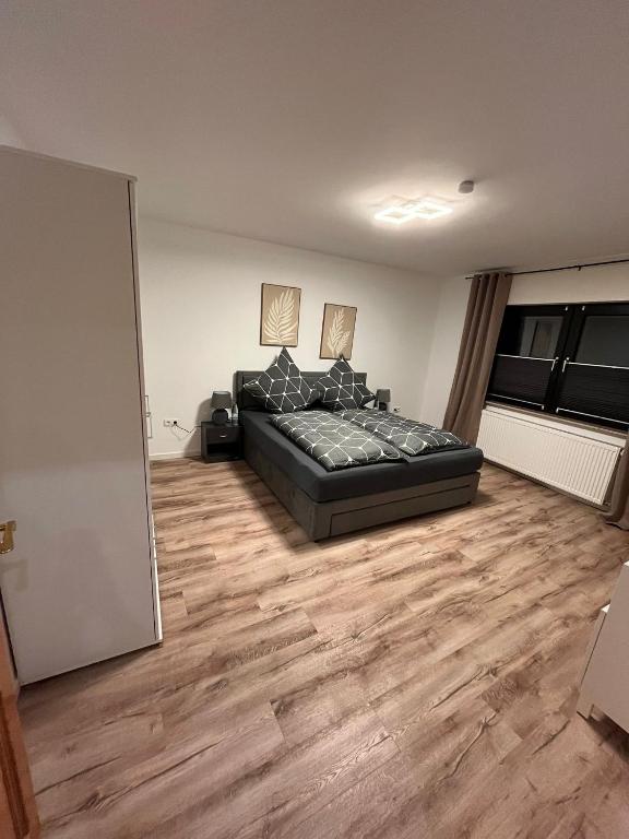 a living room with a black couch and wood floors at Ferienwohnung Marcello in Adenau