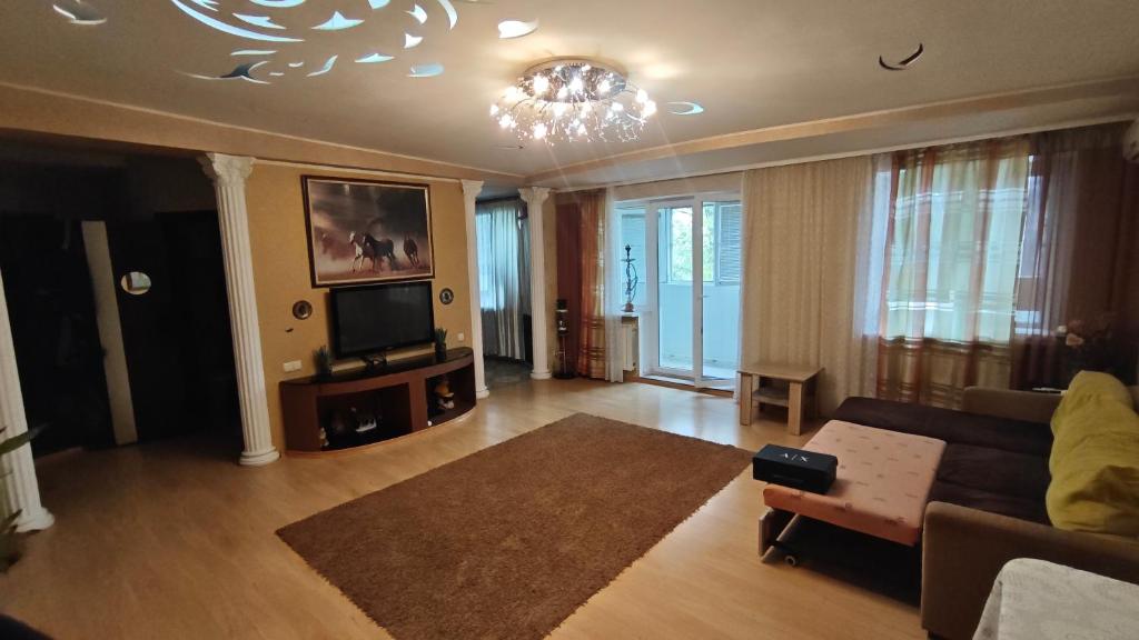 a living room with a couch and a television at Spacious apartment on Otakar Yarosh in Kharkiv