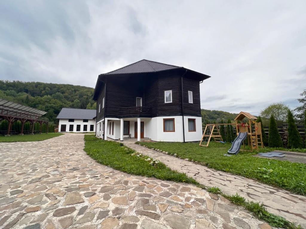 a black and white house with a playground at Casa Nelda in Marginea