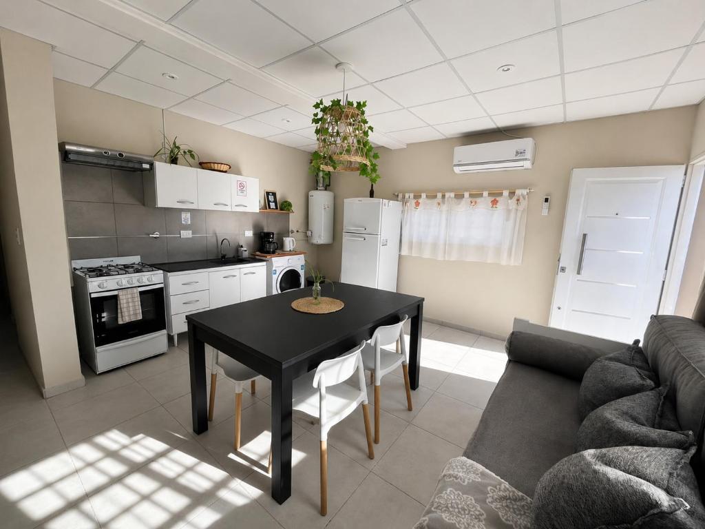 a living room with a table and a kitchen at Apart Los Laureles in Villa Regina
