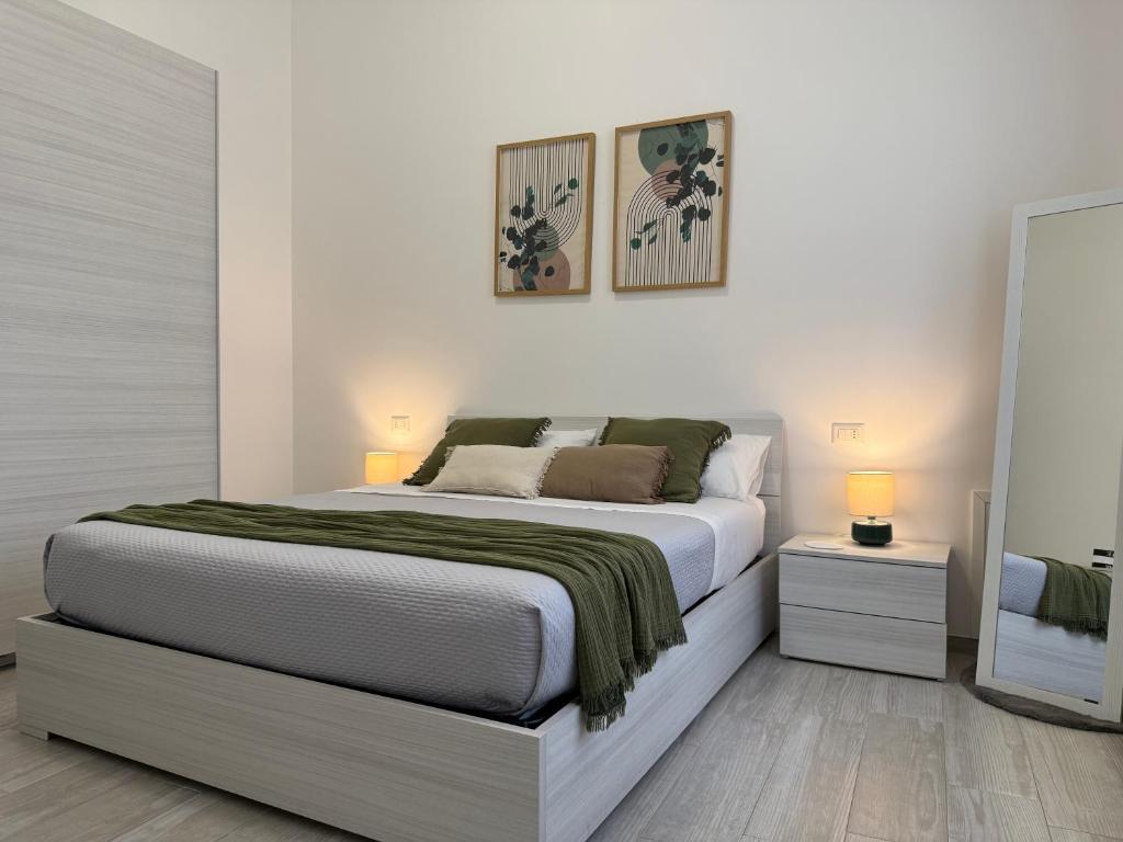a white bedroom with a large bed and two lamps at Room 28 in Conversano