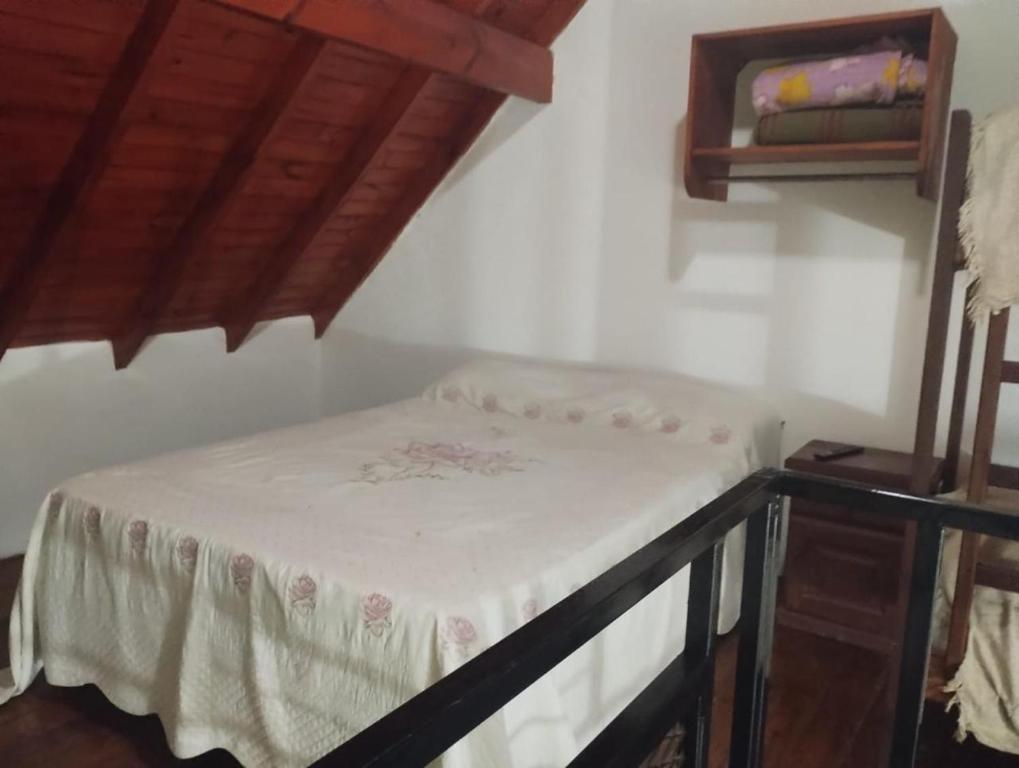 a small bed in a room with a table at El Sitio Azul Cabañas in Esquina