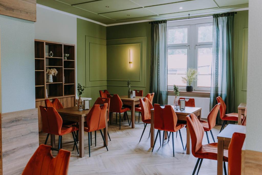 a restaurant with tables and chairs and a window at Sztuka Gór in Nowa Ruda