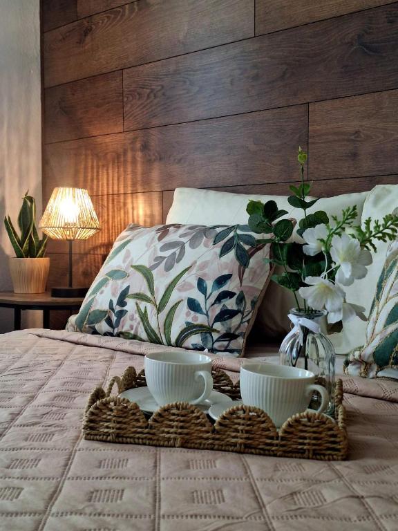 a bed with two cups and a tray on it at Solmara in Lozenets