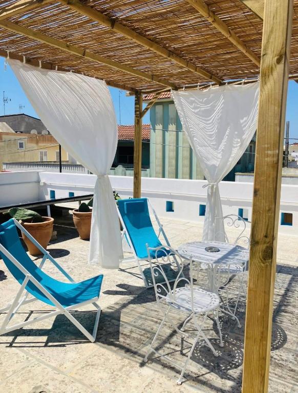 a couple of chairs and a table on a patio at Casa VersoMare Rooftop in Gagliano del Capo