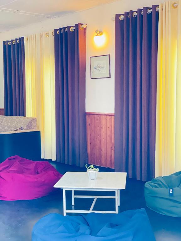 a room with colorful curtains and a white table at Mountain Lodge Ella in Bandarawela