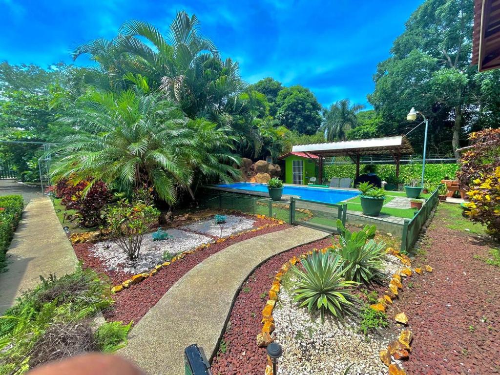 a garden with a bench and a swimming pool at La Esmeralda Villa in Orotina